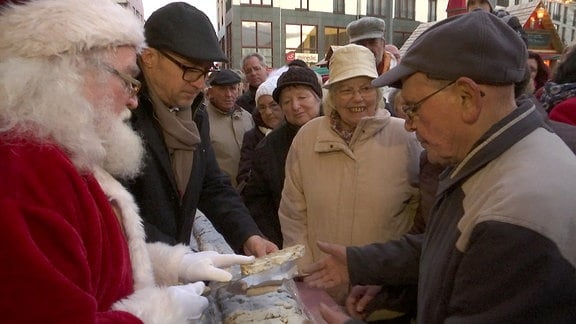 Ein Weihnachtsmann teilt Stollen aus