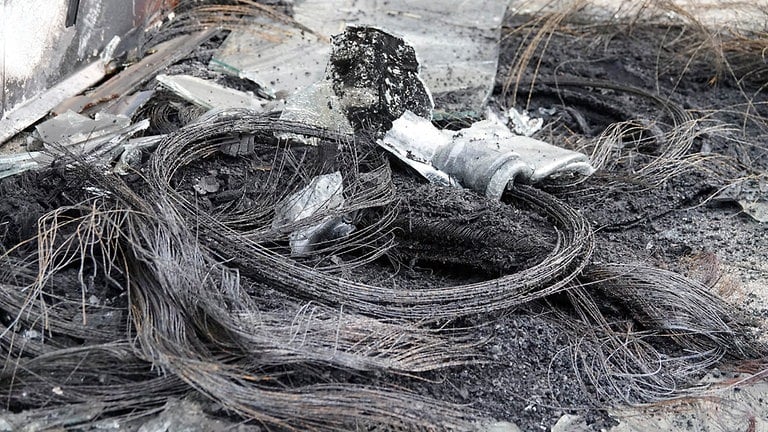 Ein Drahtgeflecht von Metallresten verbrannter Reifen liegt auf dem Boden