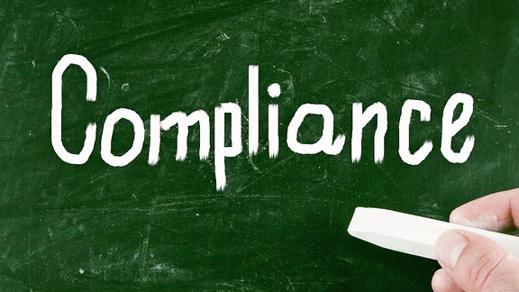 "Compliance" steht an eine Tafel geschrieben
