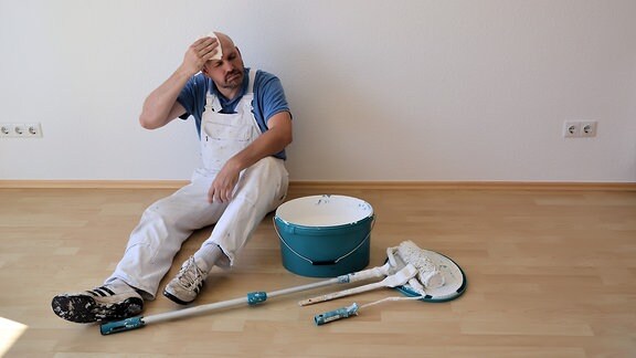 Ein Maler nach der Renovierung einer Wohnung auf einer Baustelle