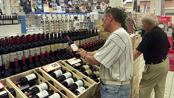 Zwei Männer kaufen regionalen Wein in einem Supermarkt