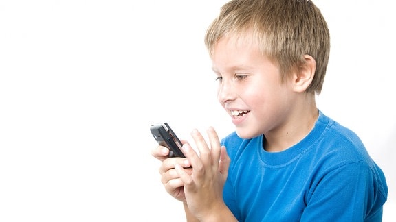 Ein Junge begutachtet ein Handy.