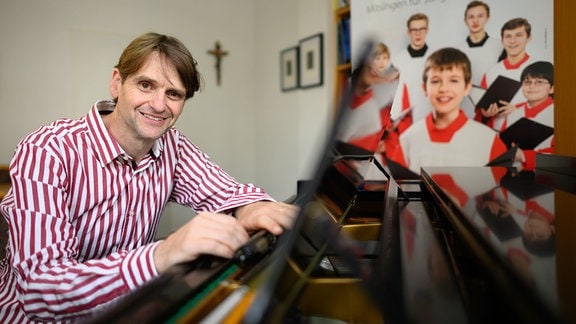 Christian Bonath, Chorleiter der Dresdner Kapellknaben, sitzt in einem Probenraum im Kapellknabeninstitut im Rahmen eines Fototermins an einem Flügel.