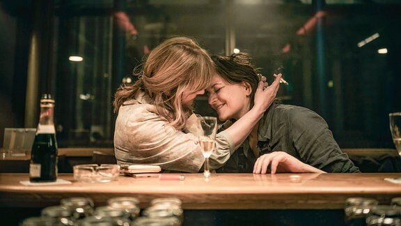 Szene aus dem Film "Die stillen Trabanten": Zwei Frauen sitzen in einer Bahnhofskneipe an der Bar. Links Nastassja Kinski und rechts Martina Gedeck.