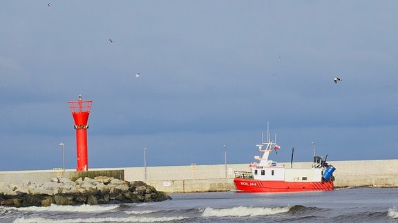 Ostsee Mrzeżyno: Ein rotweißes Schiff in der Hafeneinfahrt