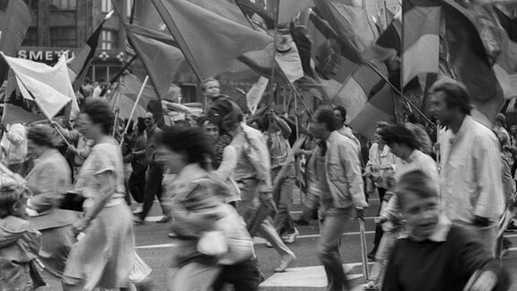 DDR, Berlin, 01.05.1987, 1. Mai Kundgebung 1987 auf der Karl-Marx-Allee, Regenschauer, Teilnehmer rennen, Fahnen wehen