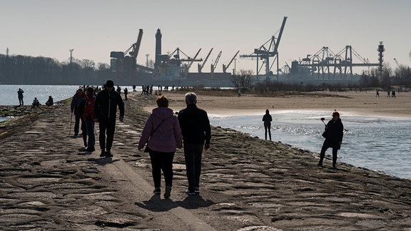Touristen auf der Westmole an der Hafeneinfahrt in Swinoujscie Swinemünde auf der Ostseeinsel Usedom in der Woiwodschaft Westpommern in Polen.