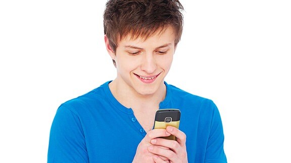 Jugendlicher mit einem Handy in der Hand.