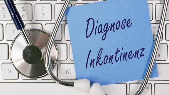 Ein Stethoskop und ein Zettel mit der Aufschrift Diagnose Inkontinenz auf einer Tastatur