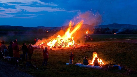 Ein Lagerfeuer brennt auf einem Feld. 