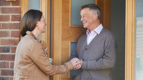 Frau besucht älteren Nachbarn.