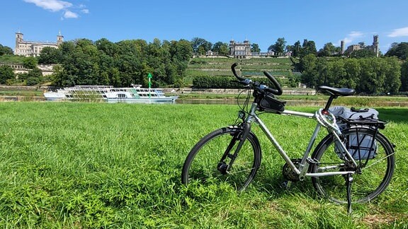 Ein Fahrrad steht am Ufer der Elbe bei Dresden.