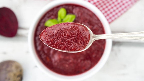 Rote-Bete-Suppe auf einem Löffel.