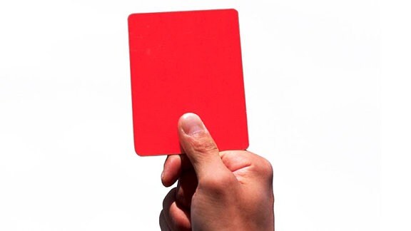 Eine Hand hält eine rote Karte hoch.