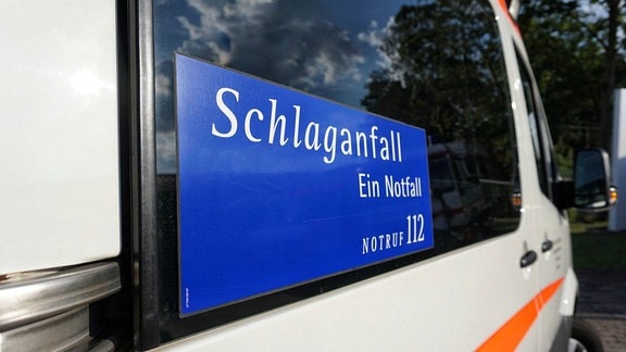 Schild auf Rettungswagen mit Aufschrift 'Schlaganfall - Ein Notfall - Notruf 112'