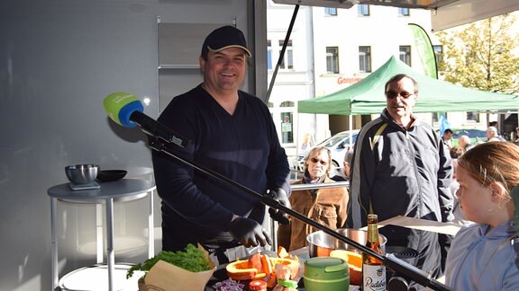 Ein Mann mit Mütze lächelt in die Kamera.