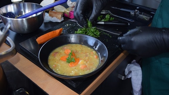 Suppe in einem schwarzen, tiefen Teller