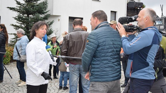 Eine Frau steht vor einem Miktofon.