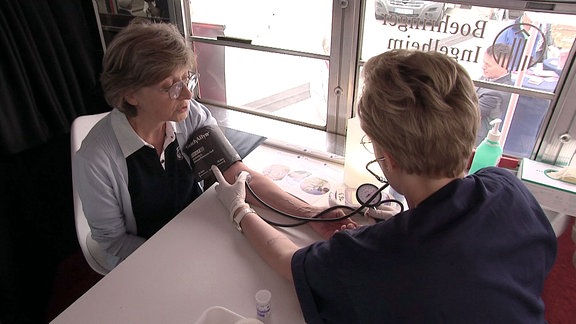 Einer Frau wird der Blutdruck gemessen.