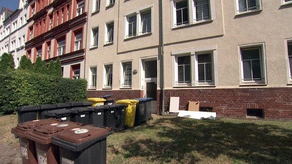 Mülltonnen vor einem Wohnhaus.