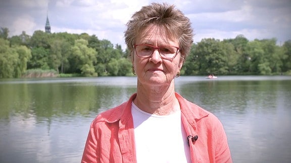 Portraitbild einer Frau, im Hintergrund ein Teich.