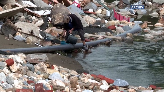 Person füllt Wasser in Eimer.