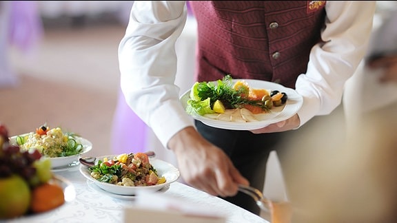 Ein Kellner serviert in einem Restaurant Essen