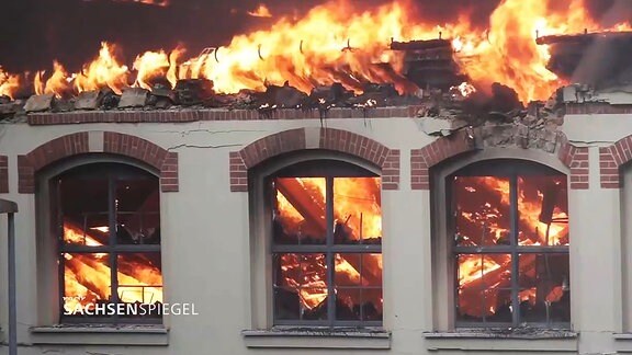 Ein Gebäude steht unrettbar in Flammen.
