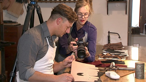Fotografin Donata Wenders schaut Handschuhmacher Nils Bergauer mit der Kamera über die Schulter