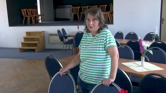 Marita Scholte steht vor leeren Stüjhhlen in ihrem Festsaal in Malschwitz