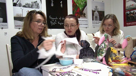 Drei Frauen unterhalten sich über Stoff