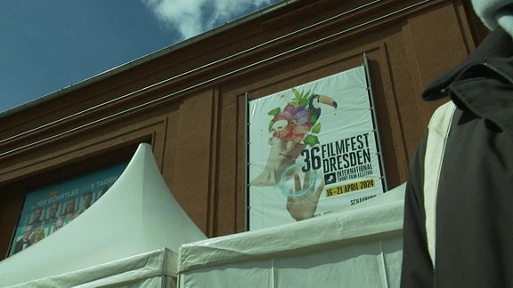 Ein Plakat des Filmfest Dresden hängt an einer Wand.
