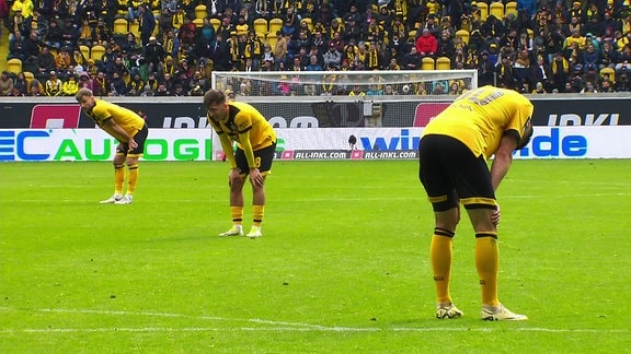 Fußballspieler von Dynamo Dresden lassen nach einem Spiel die Köpfe hängen.