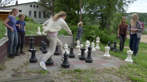 Eine Familie spielt im Freien Schach.