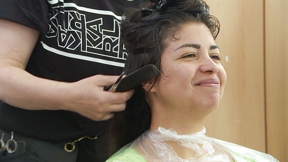 Eine Frau beim Frisör lächelt