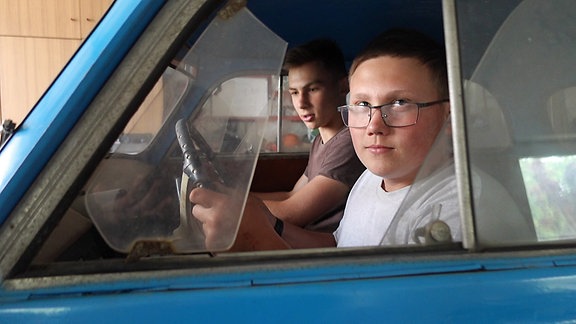 Zwei Jungen sitzen in einem Auto.