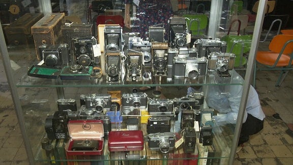 Glasvitrine voll mit alten Fotokameras