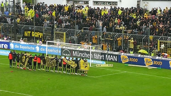 Die Spieler von Dynamo Dresden jubeln vor ihrer Fankurve.