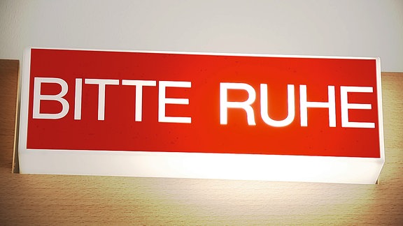 Eine leuchtende rot-weiße Leuchte mit der Aufschrift "BITTE RUHE"