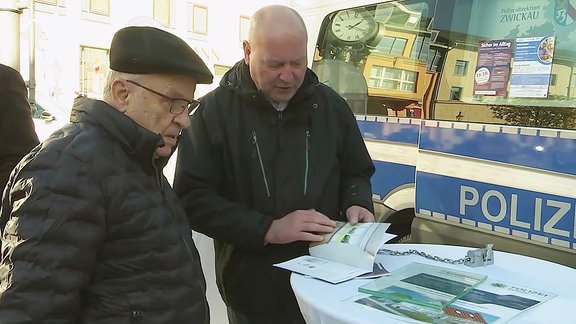 Männer an einem Infostand