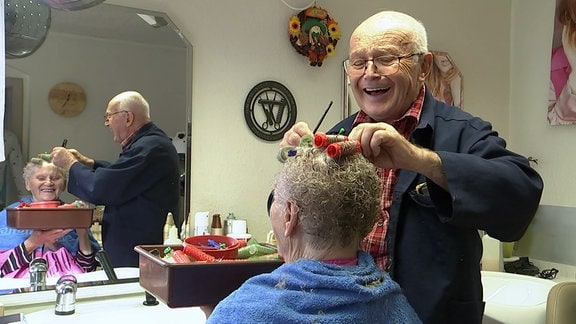 Friseurmeister Johannes Höppner wohlgelaunt beim Frisieren 