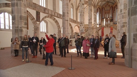 Gruppe Jounalisten folgt den Ausfürhungen der Stadtführerin in einer Kirche in Chemnitz