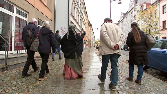 Eine Frau in Verkleidung gibt eine Führung