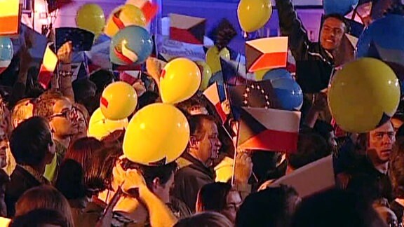 Menschen feiern mit Fähnchem und Luftballons