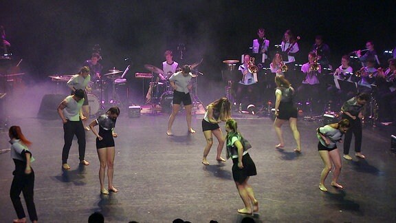 Menschen tanzen auf einer Bühne