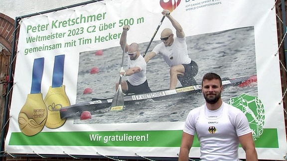 Peter Kretschmer vor einem Plakat zu seinem Weltmeistertitel