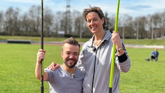 Mathias Mester und Steffi Nerius draussen mit Speer stehend, lachend