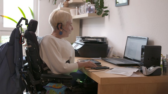 Eine Frau sitzt vor einem Computer.