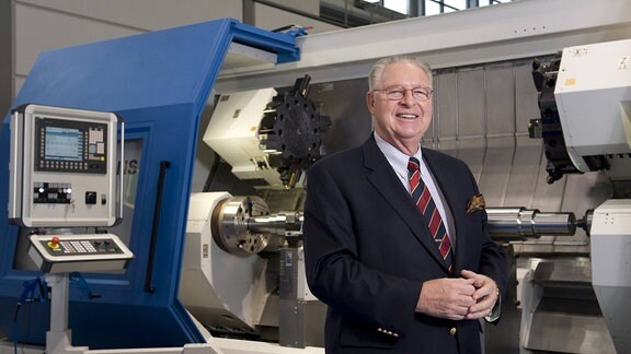Hans J. Naumann (Geschäftsführer Niles-Simmons Industrieanlagen GmbH) vor einer CNC Drehmaschine N30 LT auf der Messe INTEC in Leipzig