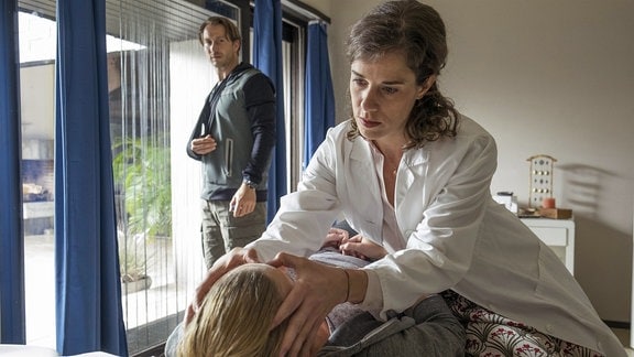 Lauber (David Rott) beobachtet misstrauisch, wie seine Kollegin Janne Jarst (Anne Schäfer) Lisa (Sophia Schober) behandelt und alternative Methoden anwendet.